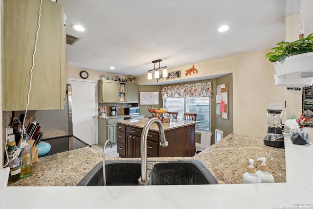 kitchen with visible vents, decorative backsplash, decorative light fixtures, a sink, and recessed lighting