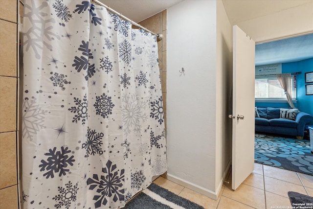 ensuite bathroom with a shower with curtain, baseboards, ensuite bathroom, and tile patterned floors