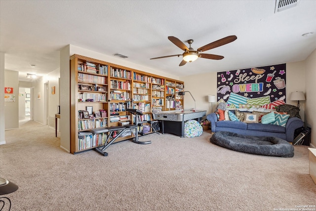 sitting room with carpet floors, visible vents, and a ceiling fan