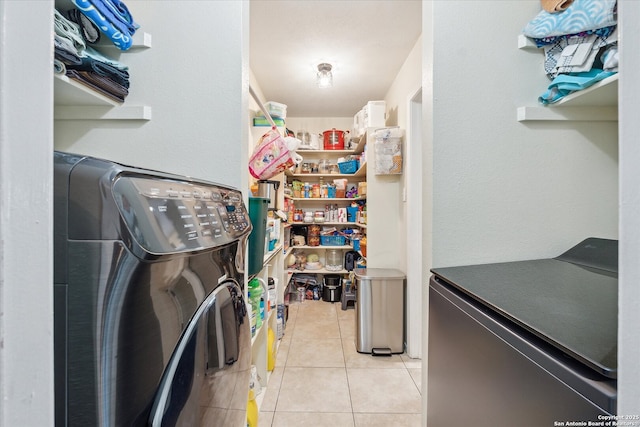 interior space featuring washing machine and clothes dryer and light tile patterned floors