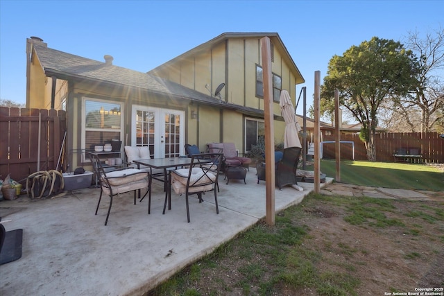 rear view of house with a patio, fence, french doors, a lawn, and roof with shingles