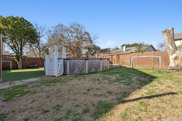 view of yard with fence and a pool