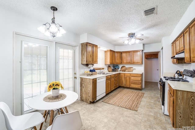 kitchen with a sink, visible vents, brown cabinets, dishwasher, and gas range oven