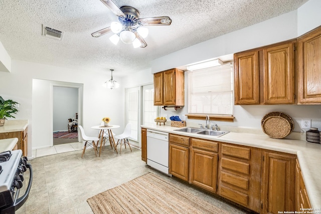 kitchen with brown cabinets, visible vents, dishwasher, and a sink