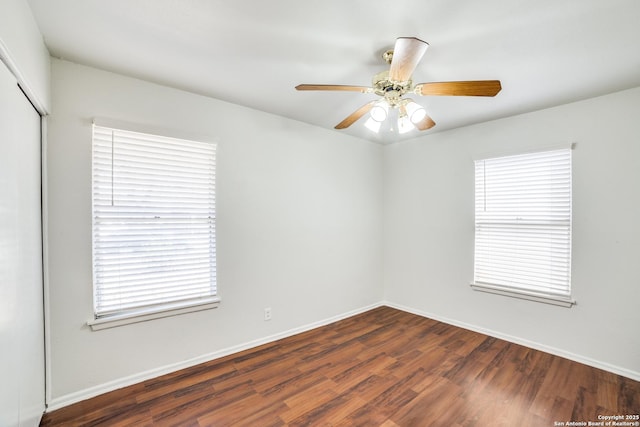 unfurnished room with ceiling fan, wood finished floors, and baseboards