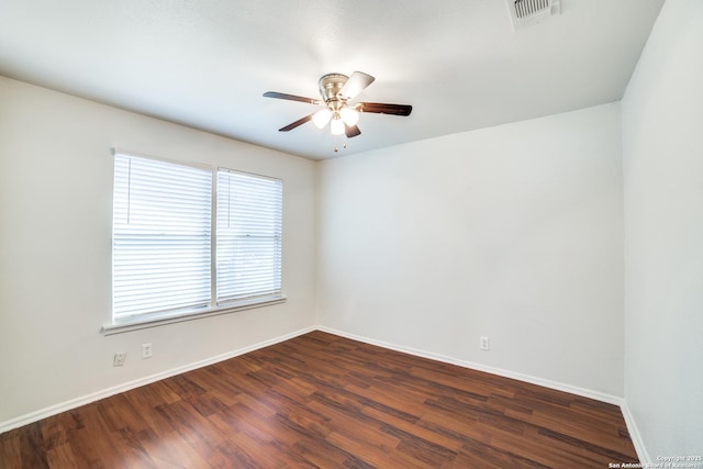 spare room with ceiling fan, dark wood finished floors, visible vents, and baseboards