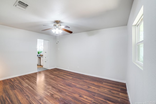 spare room with a ceiling fan, baseboards, visible vents, and wood finished floors