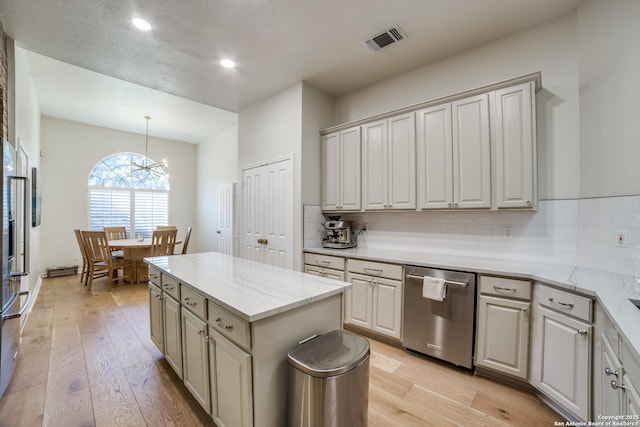 kitchen with dishwasher, light wood-style flooring, visible vents, and tasteful backsplash