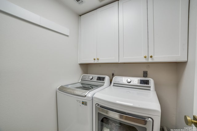 laundry area featuring separate washer and dryer and cabinet space