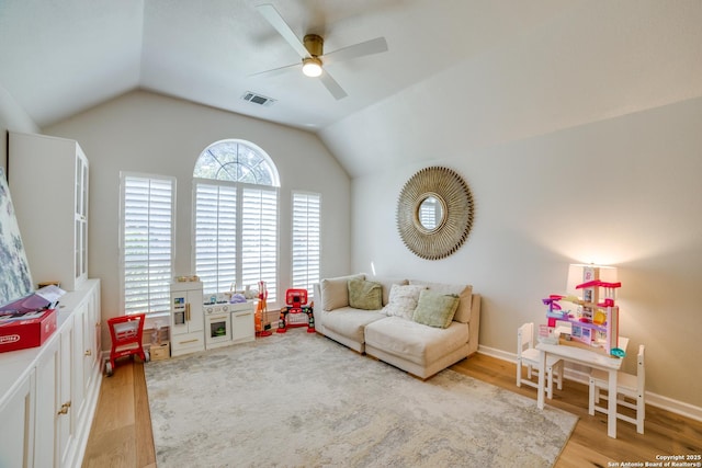 playroom with vaulted ceiling, light wood-type flooring, a ceiling fan, and baseboards