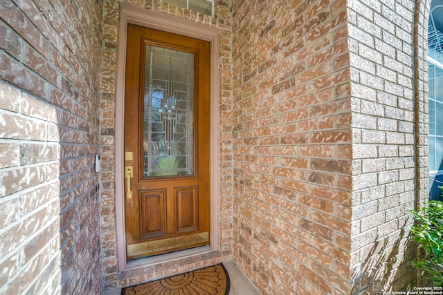 view of exterior entry with brick siding