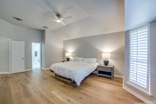 bedroom featuring light wood-type flooring, visible vents, vaulted ceiling, and baseboards