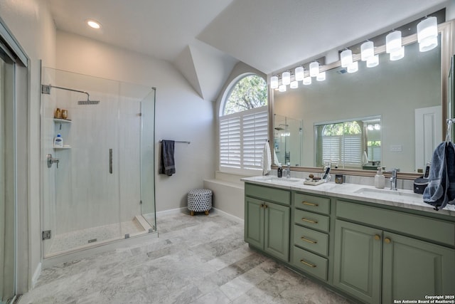 bathroom with vaulted ceiling, double vanity, a stall shower, and a sink