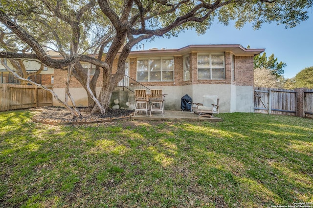 rear view of property featuring a patio area, a fenced backyard, a lawn, and brick siding