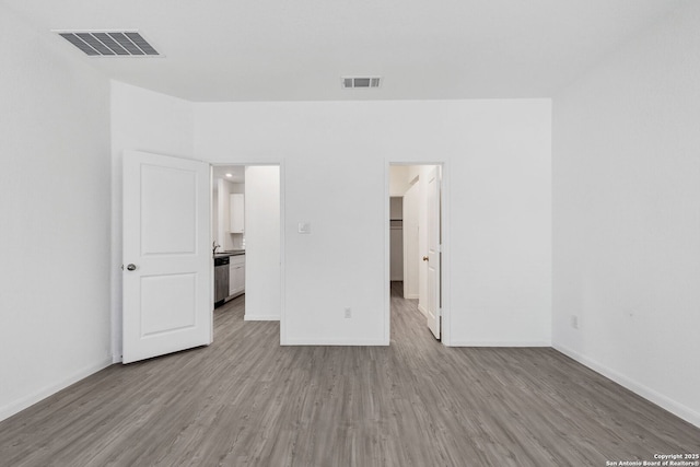 unfurnished bedroom with visible vents, baseboards, and wood finished floors