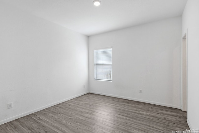 unfurnished room featuring baseboards and wood finished floors