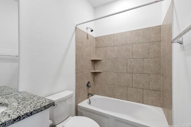 full bath featuring toilet,  shower combination, a textured wall, and vanity