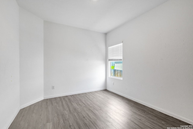 empty room with baseboards and wood finished floors