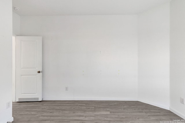 empty room featuring wood finished floors and baseboards