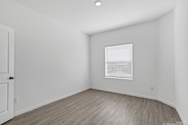 empty room featuring wood finished floors and baseboards