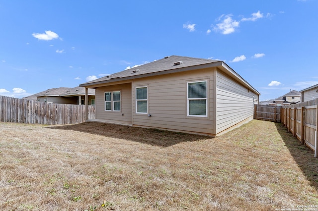 back of house featuring a lawn and a fenced backyard