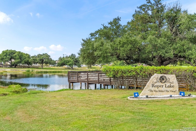 dock area with a water view and a lawn