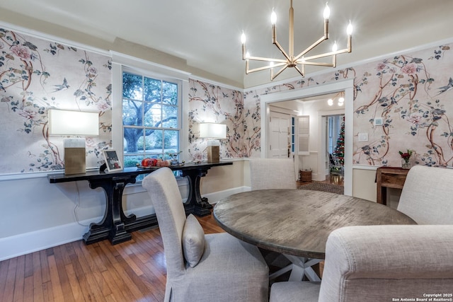 dining room featuring baseboards, wood-type flooring, and wallpapered walls