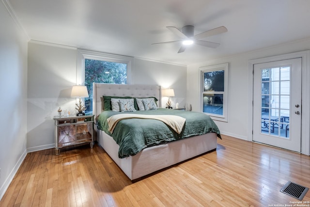 bedroom featuring baseboards, hardwood / wood-style floors, visible vents, and crown molding