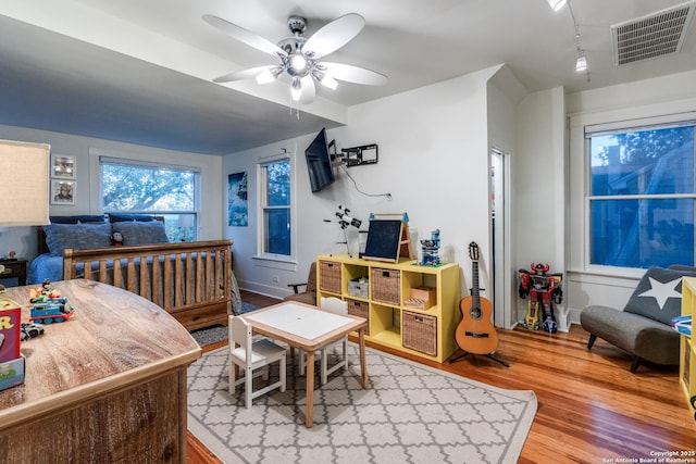 interior space with visible vents, ceiling fan, and wood finished floors