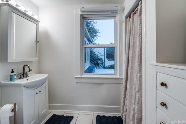 full bathroom with tile patterned flooring, vanity, and baseboards