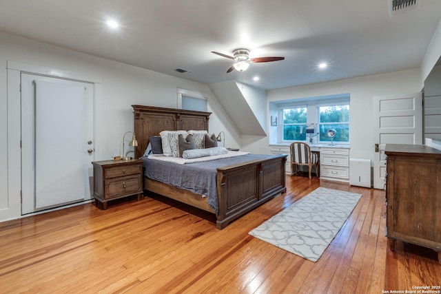 bedroom with light wood finished floors, built in desk, visible vents, and recessed lighting