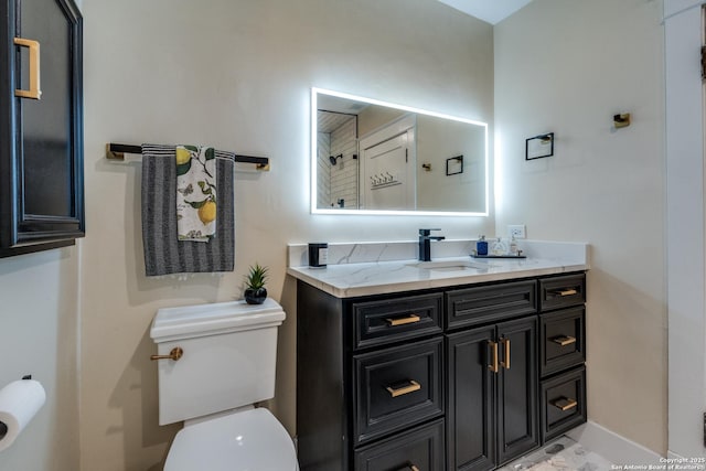 bathroom with vanity, toilet, and baseboards