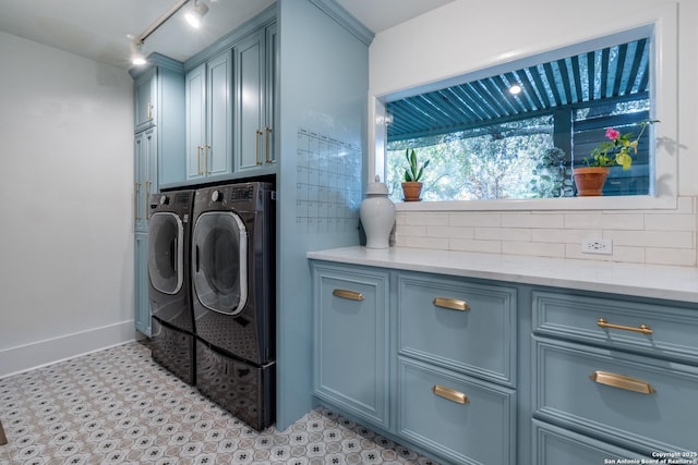 laundry area featuring cabinet space, baseboards, washing machine and clothes dryer, light floors, and track lighting