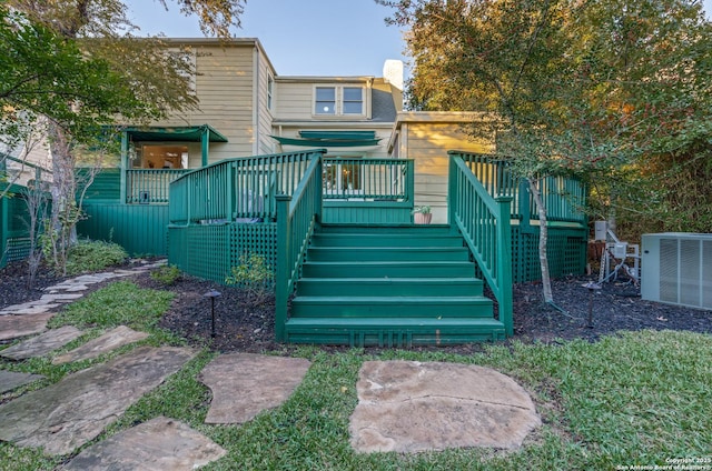 back of property with central air condition unit, stairway, and a deck