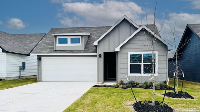 view of front of property with concrete driveway, a shingled roof, board and batten siding, and a front yard