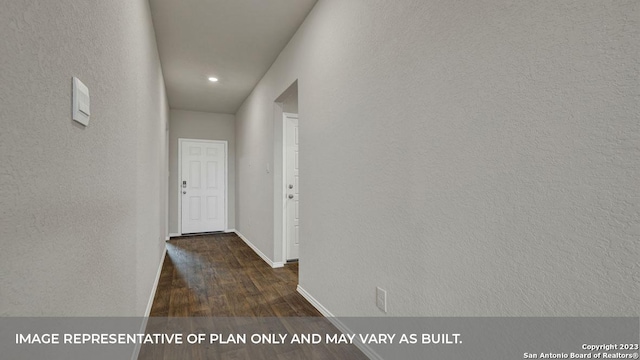 hallway featuring a textured wall, baseboards, and wood finished floors