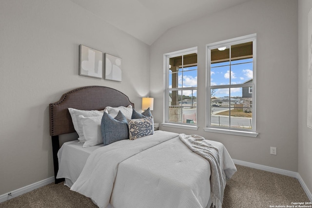 bedroom with lofted ceiling, baseboards, and carpet flooring