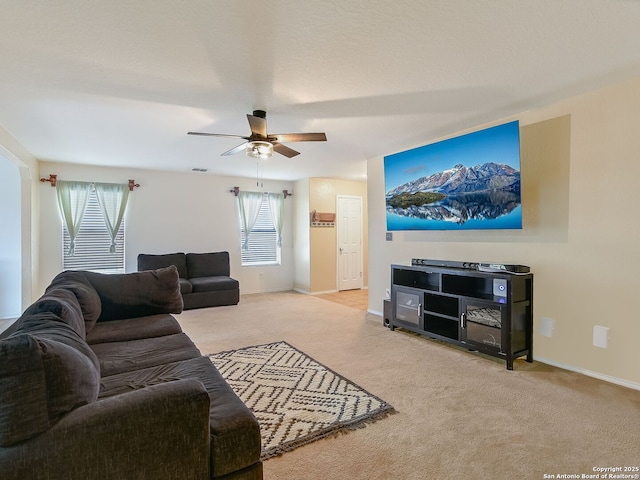 carpeted living area with a ceiling fan, visible vents, and baseboards