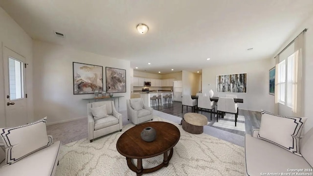 living area with recessed lighting, carpet flooring, visible vents, and baseboards