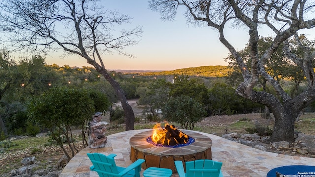 patio terrace at dusk featuring an outdoor fire pit