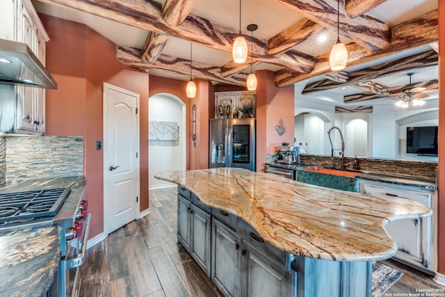 kitchen with tasteful backsplash, arched walkways, coffered ceiling, dark wood finished floors, and appliances with stainless steel finishes