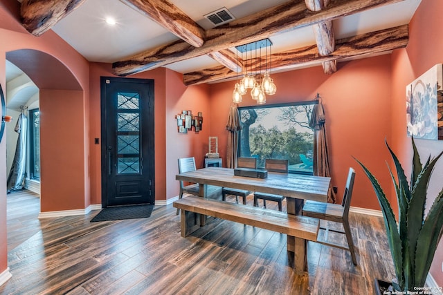 dining area featuring baseboards, visible vents, arched walkways, and wood finished floors