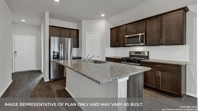 kitchen with light stone counters, appliances with stainless steel finishes, dark brown cabinets, and a sink