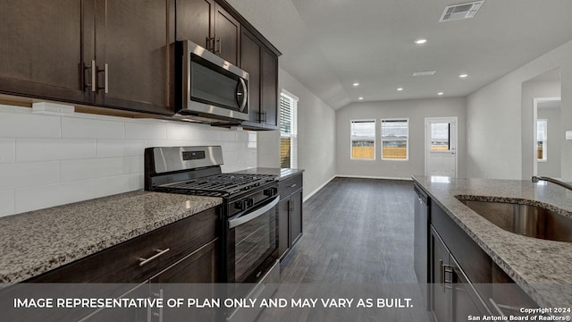 kitchen featuring stainless steel appliances, tasteful backsplash, visible vents, a sink, and light stone countertops