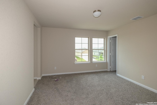 carpeted spare room with baseboards