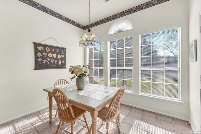 dining area with light tile patterned floors, baseboards, a chandelier, and a textured ceiling