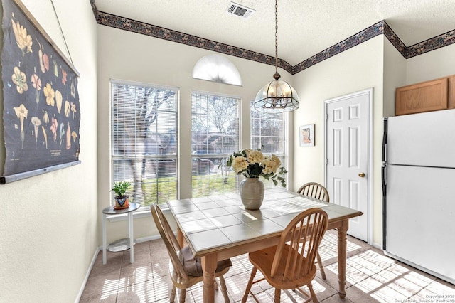 dining area with visible vents, a textured ceiling, baseboards, and light tile patterned floors