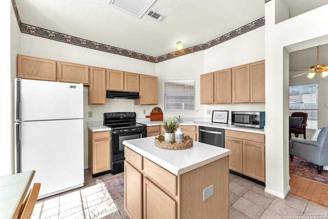 kitchen with a textured ceiling, under cabinet range hood, visible vents, light countertops, and appliances with stainless steel finishes