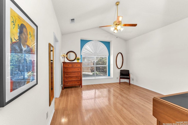 sitting room with lofted ceiling, light wood-style floors, visible vents, and a ceiling fan