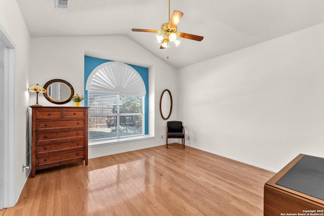 sitting room with visible vents, a ceiling fan, lofted ceiling, a textured ceiling, and light wood-type flooring